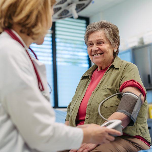 Senior woman having blood pressure checked during preventive medical exam